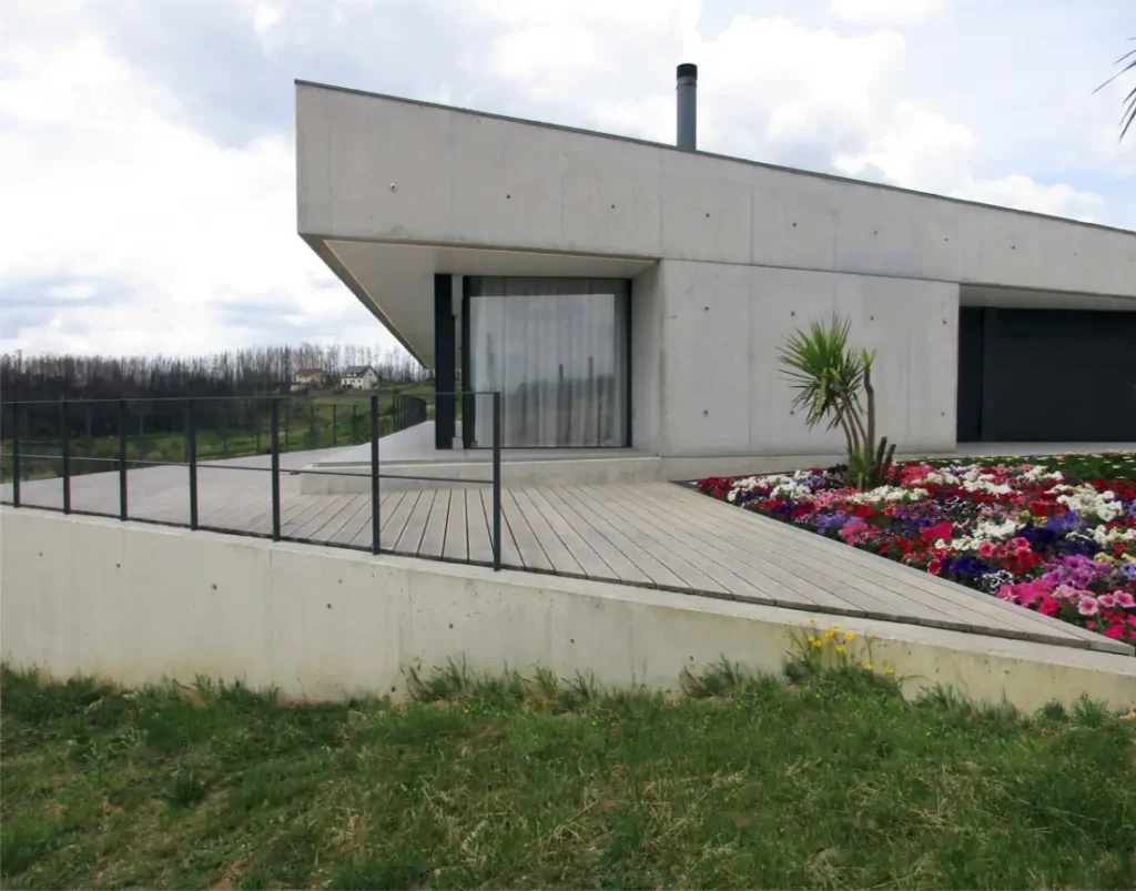 Wood deck and flowers on the garden of the concrete house